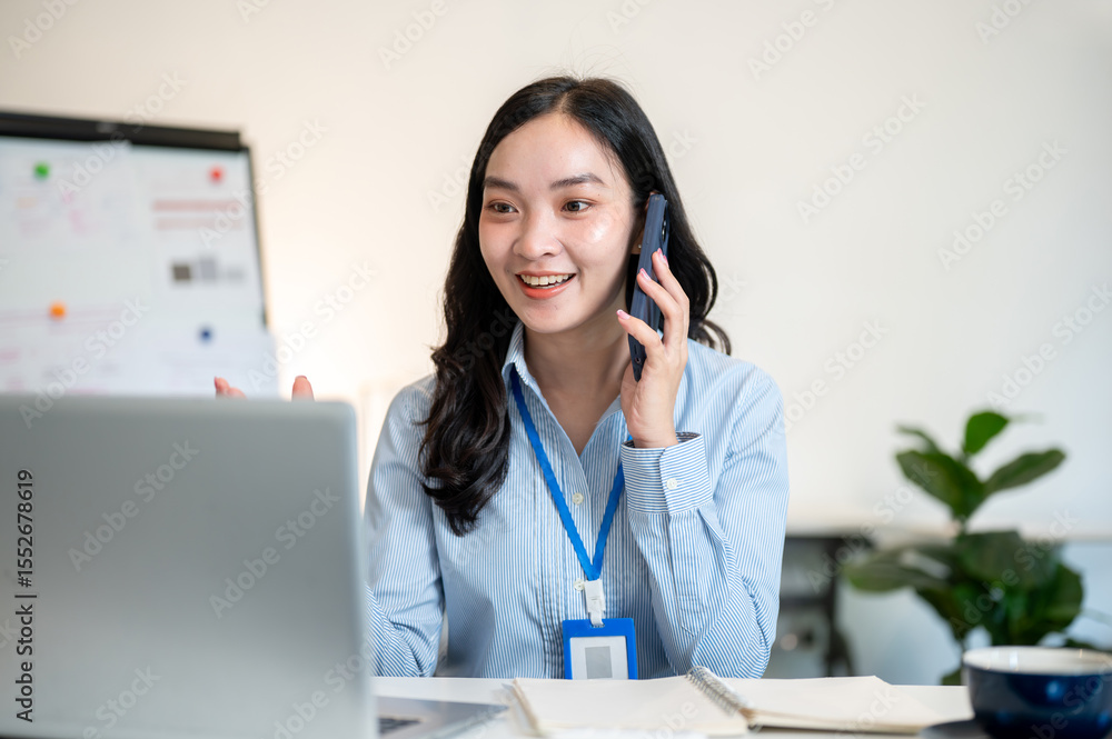 Female office worker businesswoman talking with customer on phone sitting at working table in office Female office worker businesswoman talking with customer on phone sitting at working table in office