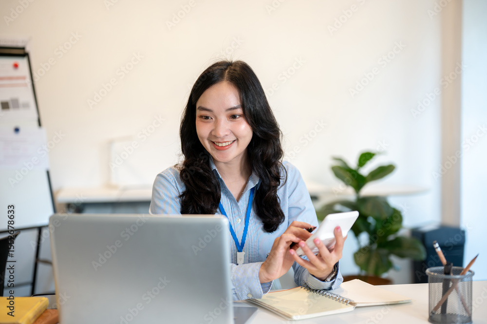 Smiling female office worker or accountant holding calculator looking at laptop sits at work table. Smiling female office worker or accountant holding calculator looking at laptop sits at work table.