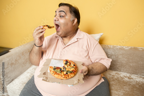 Quadro su tela Hungary overweight fat indian man eating cheese pizza