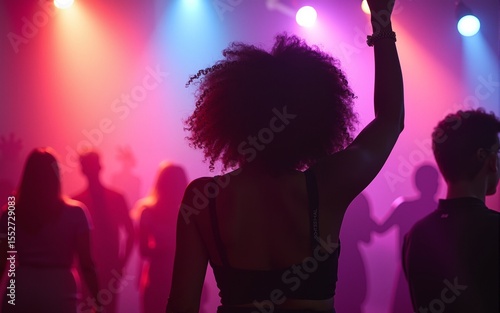 A young, beautiful black woman dancing at the club surrounded by the colorful lights. Rave, concert, party, event photography. High quality
