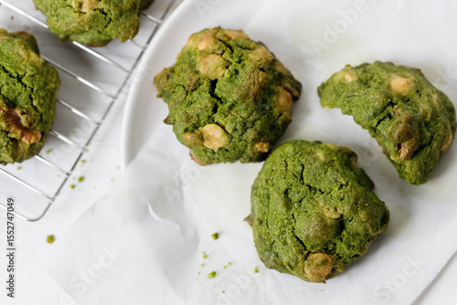 Closeup of fresh baked matcha cookies on white wooden background.