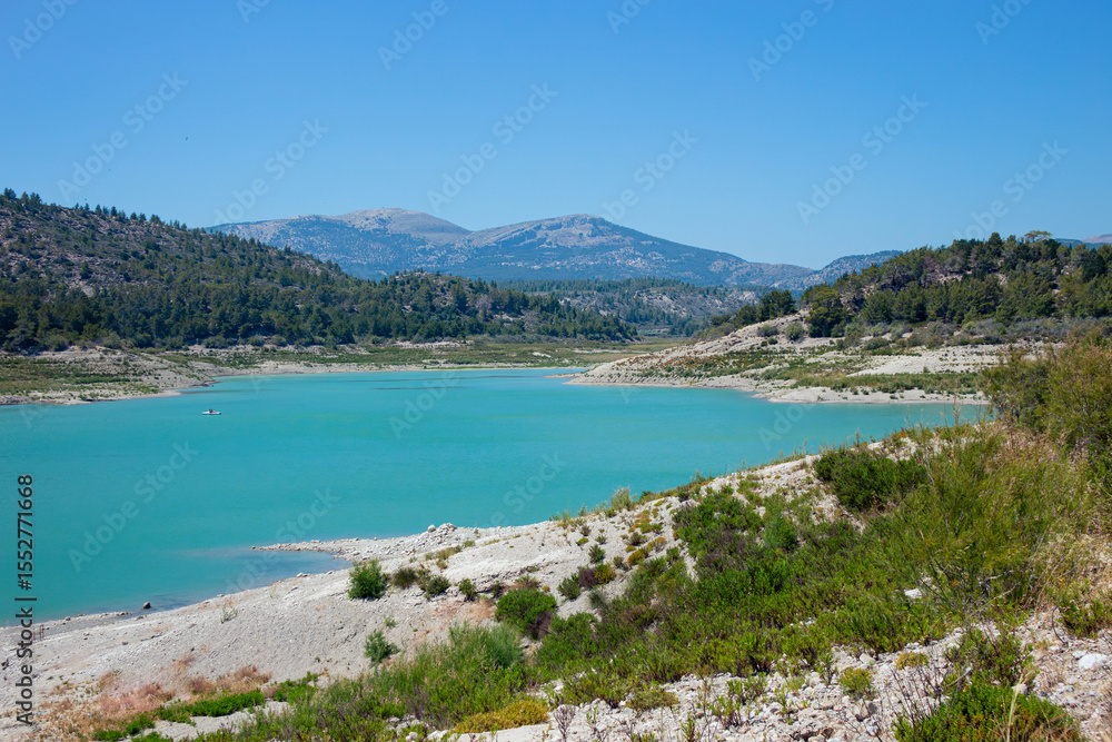 Apolakkia dam lake in Rhodes in Greece. Beautiful blue color Apolakkia Reservoir lake between mountains and forest. Apolakkia dam lake in Rhodes in Greece. Beautiful blue color Apolakkia Reservoir lake between mountains and forest.
