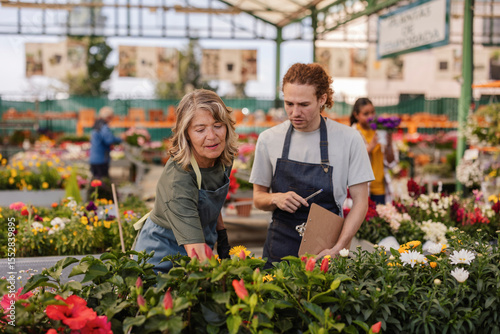 Wallpaper Mural Gardener and customer discussing plants in a flower market Torontodigital.ca