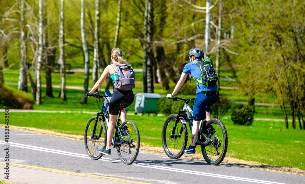 Fototapeta premium Cyclists ride on the bike path in the city Park 