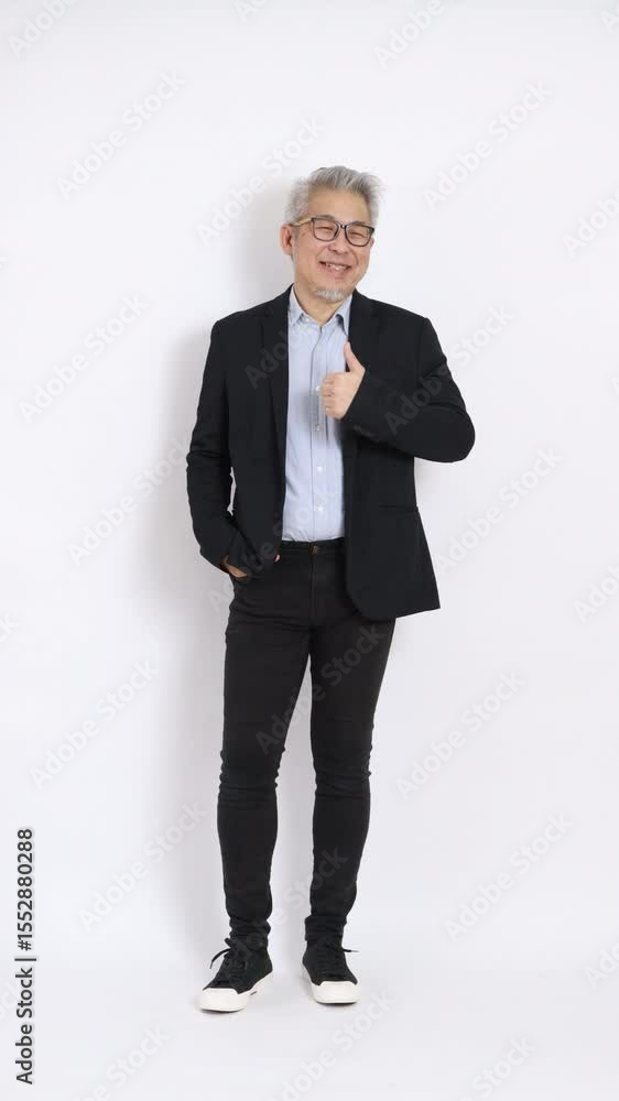 This is a portrait of an East Asian businessman with gray hair and glasses, dressed in a black suit, standing against a white background. This is a portrait of an East Asian businessman with gray hair and glasses, dressed in a black suit, standing against a white background.