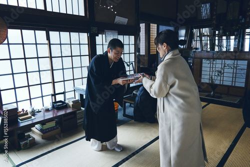 伝統的な日本寺院で御朱印帳を手渡す僧侶