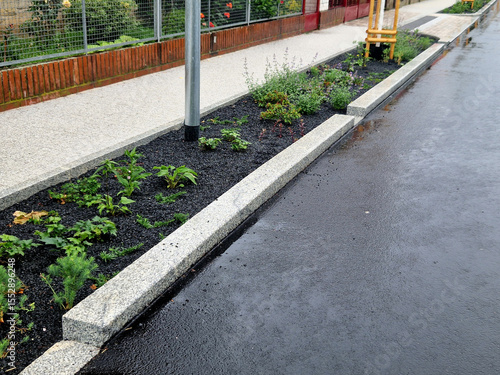фотографія Water from the road is absorbed through the gaps in the curb and the slope of the asphalt towards the edge