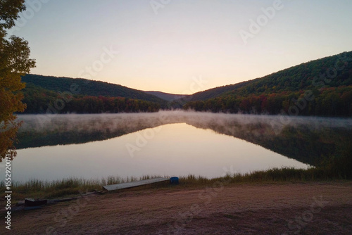 Misty morning tranquility over a serene lake at sunrise