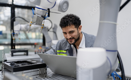 Latino robotic development engineer working robot arm connection control at electronic futuristic science laboratory. Hispanic technician learning innovation machine in automated engineering academy.