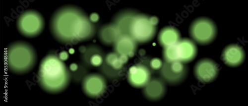 Green blurred bokeh particles with varying size and opacity on black background. Abstract design element for festive or sci-fi scenes.