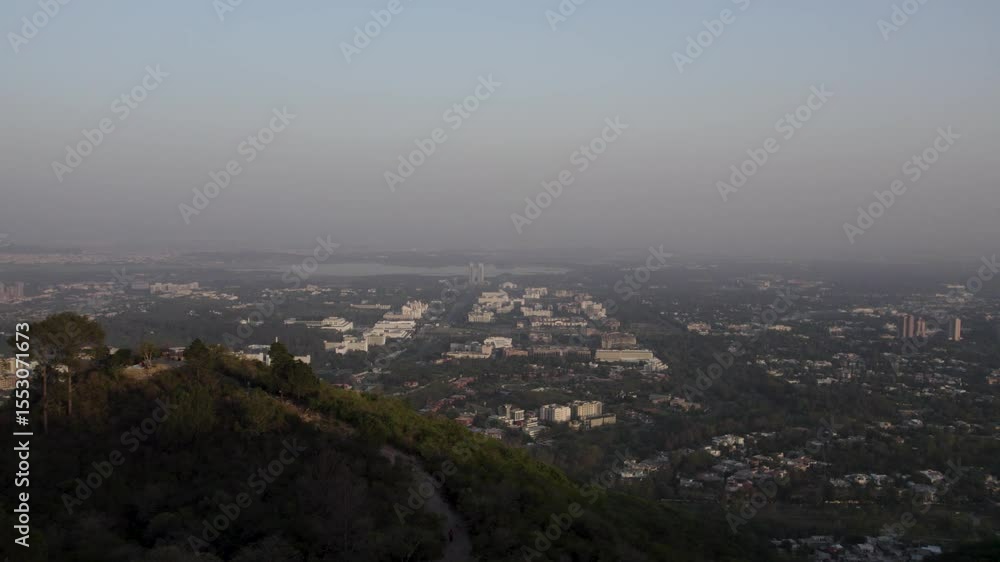 Wide aerial view of Islamabad city at dusk with Margalla Hills in foreground and grid layout. Islamabad Wide aerial view of Islamabad city at dusk with Margalla Hills in foreground and grid layout. Islamabad