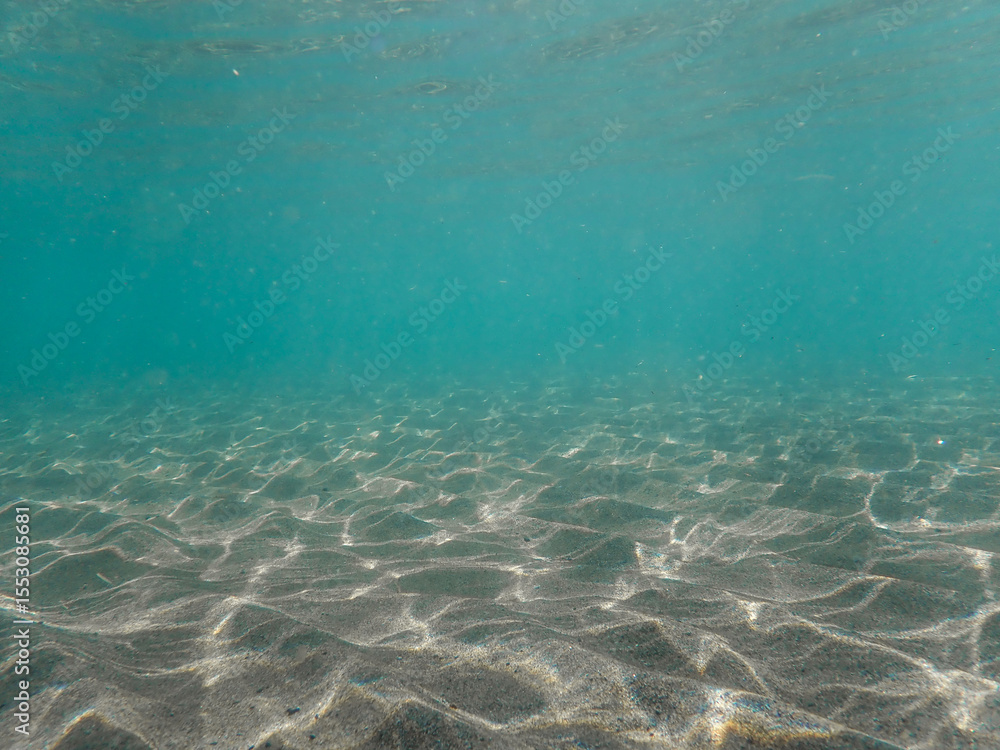 Fototapeta premium Ocean blue underwater with sunrays, Underwater Sea Deep Water Abstract Sunshine, sea wave , clean waters in summer time, Natural underwater seascape, sand on ocean floor and water surface with sunligh