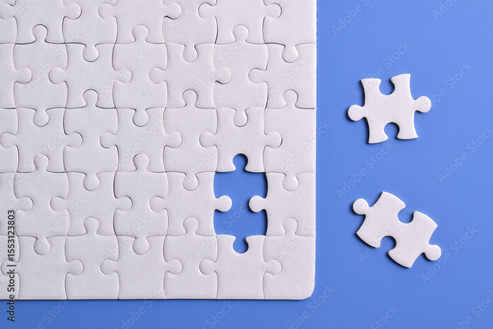 White puzzle with missing piece on blue background. Flat lay. Top view White puzzle with missing piece on blue background. Flat lay. Top view