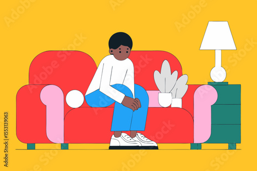 Smiling African American boy tying his shoelaces on the sofa in a cozy living room
