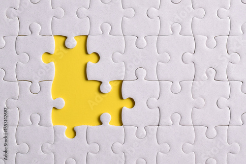 Close up white jigsaw puzzle on yellow background, planning and manage to success business, smart idea and teamwork concept