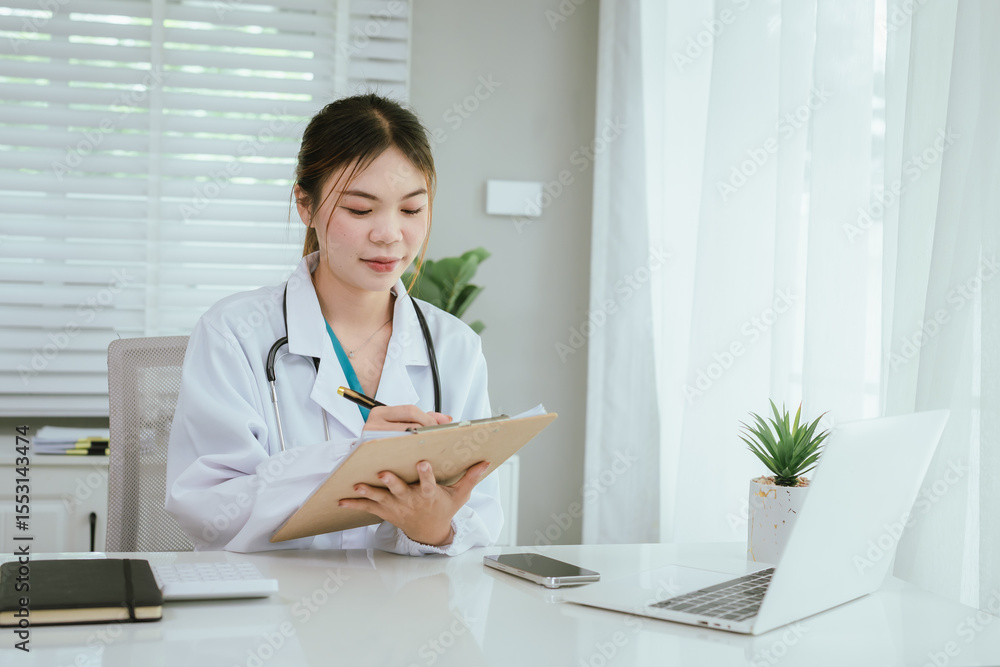 A professional in medical attire is diligently reviewing documents on a clipboard while also engaging with a laptop. A professional in medical attire is diligently reviewing documents on a clipboard while also engaging with a laptop.