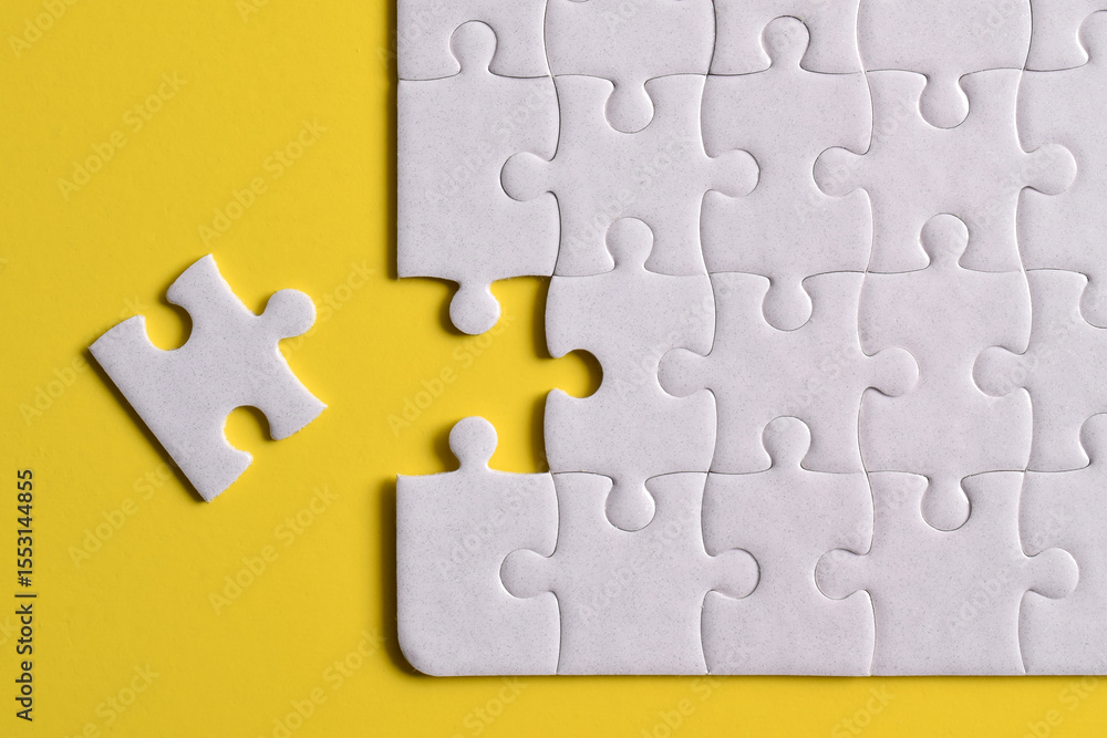 Fototapeta premium White puzzle pieces on yellow background. Flat lay. Top view