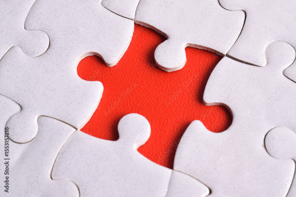 Fototapeta premium White puzzle with missing piece on red background, closeup