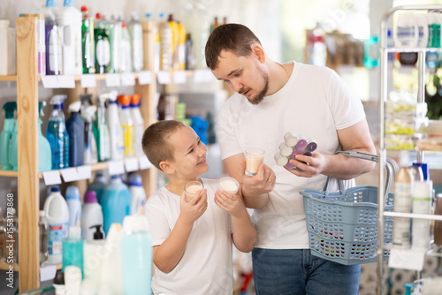 Foto Dad tells son about choosing household goods, shows him suitable interior scented candles, and explains what to look for quality when buying