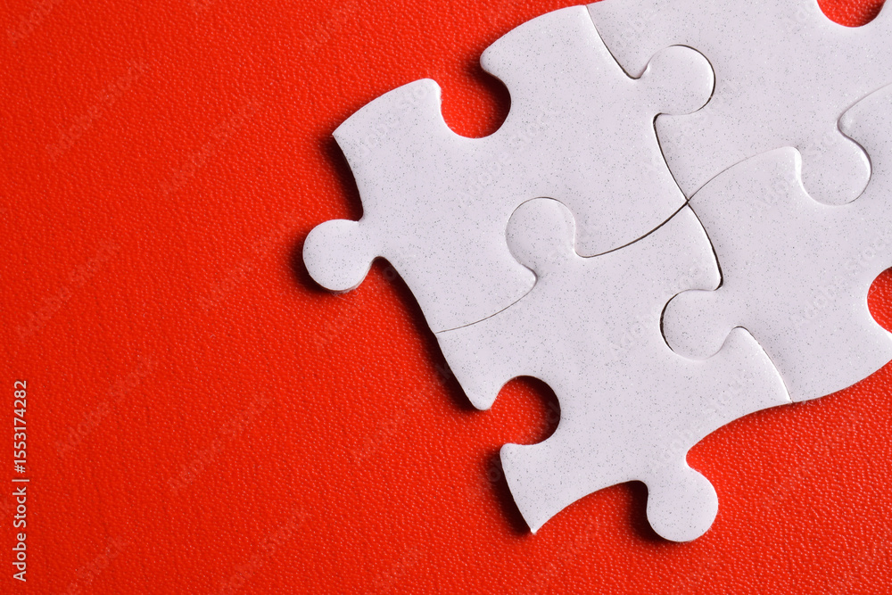 Fototapeta premium White puzzle pieces on red background, top view