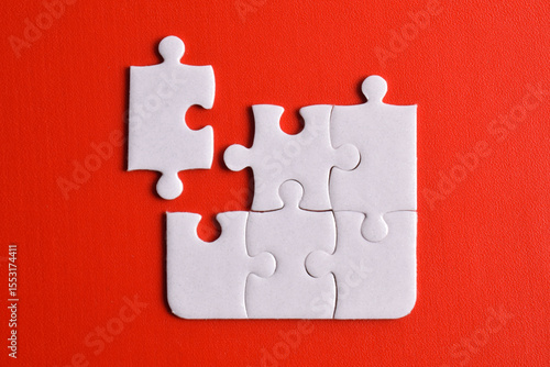 White puzzle pieces on red background. Flat lay. Top view