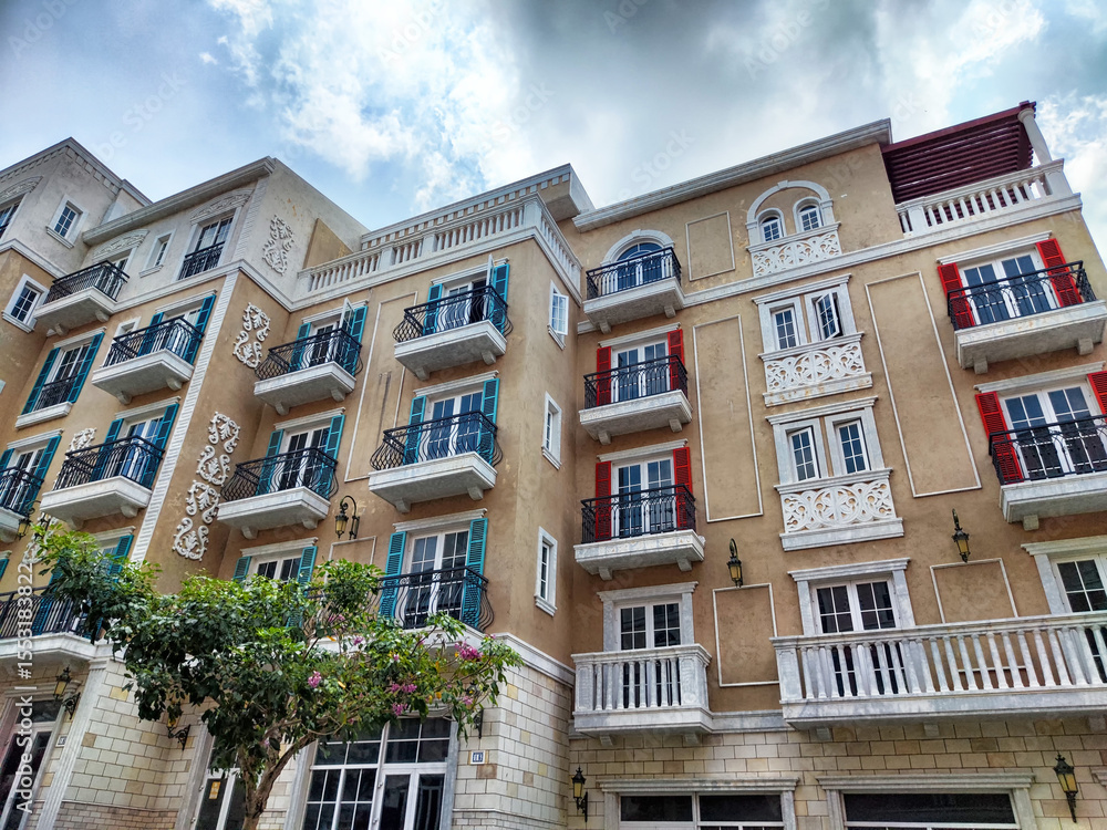 Fototapeta premium The stunning historic architecture, adorned with vibrant balconies, vividly embodies the essence of urban living. Set against a dramatic sky, this lively neighborhood exudes charm and character