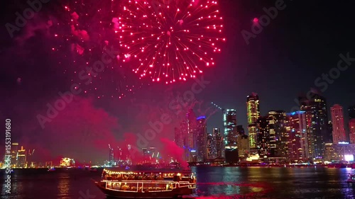Fireworks display show seen from the water with Dubai skyline in the background at night