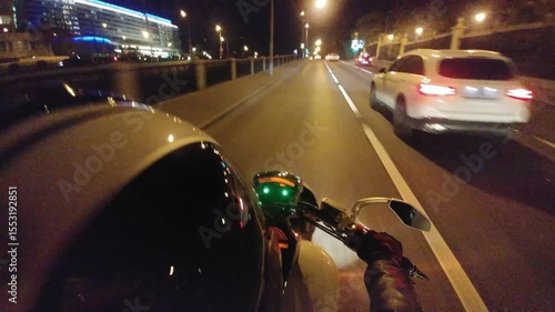 Motorcycle rider is taking a picture of the road. The road is empty and the rider is wearing a helmet