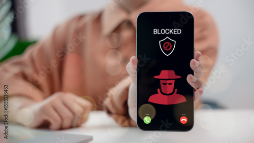 Foto Phone screen showing scam call blocked with hacker icon and security shield