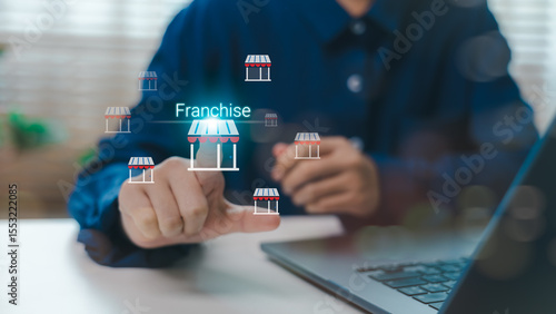 Businessman touching virtual franchise icon with shop symbols, concept of franchise model, business growth strategy, investment opportunity and retail expansion network.
