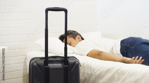 a man sleeping on a comfortable bed in a hotel room after arriving from a trip