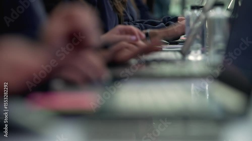 Group of People Typing on Keyboards – Office or Tech Workspace. A team of individuals working side by side, typing on computer keyboards. Office collaboration, coding, data entry.