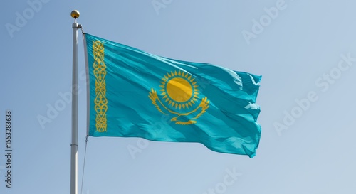 Kazakhstan's vibrant flag billows proudly against a clear blue sky.
