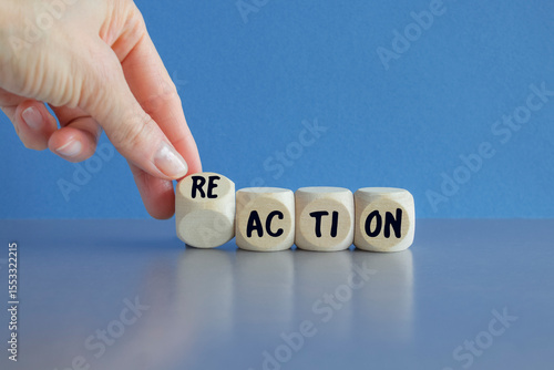 Hand turns dice and changes the word action to reaction. Beautiful blue background. Business and action to reaction concept.