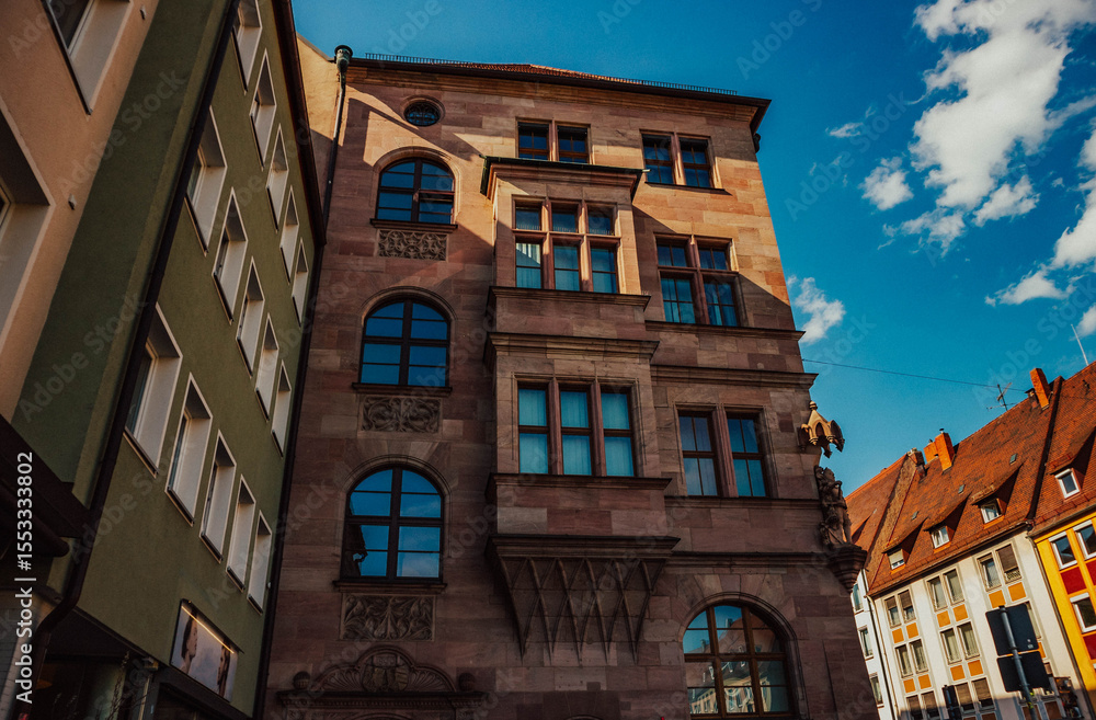 Naklejka premium Old architectural building in Nuremberg city against blue bright sky. Cityscape