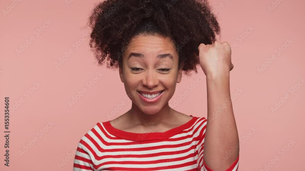Excited young woman celebrating success joyfully on pink background Excited young woman celebrating success joyfully on pink background