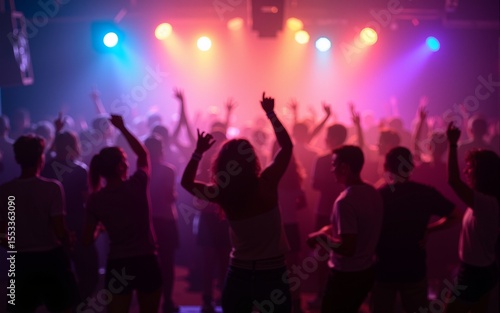 Crowd dancing under colorful lights at a lively party or concert. High quality