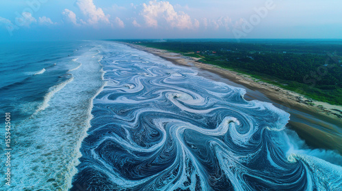 Aerial view of ocean waves meeting shoreline, creating swirling patterns.