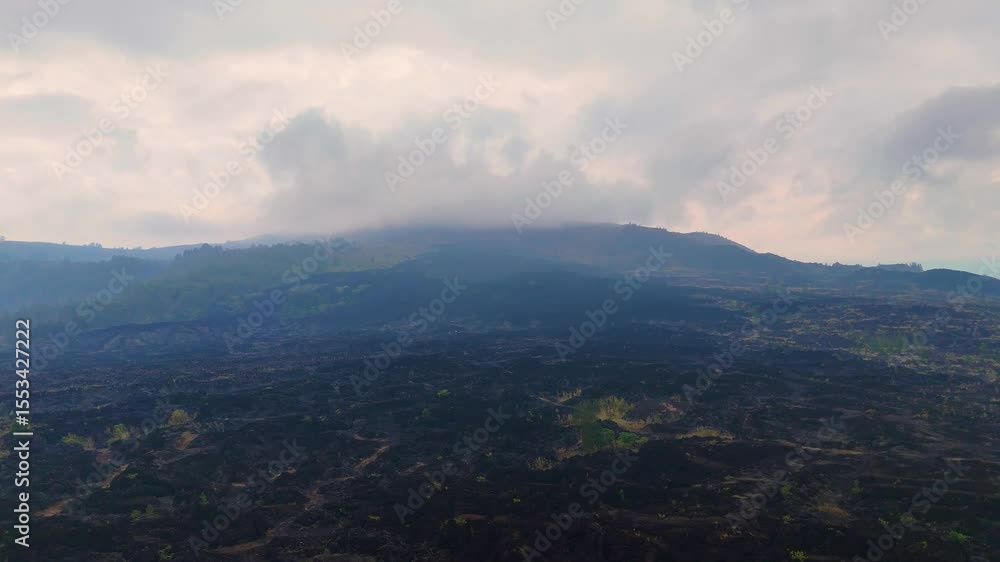 Aerial drone view flying over cold, black volcanic lava flows from an active volcano Mount Batur, Bali, Indonesia Aerial drone view flying over cold, black volcanic lava flows from an active volcano Mount Batur, Bali, Indonesia
