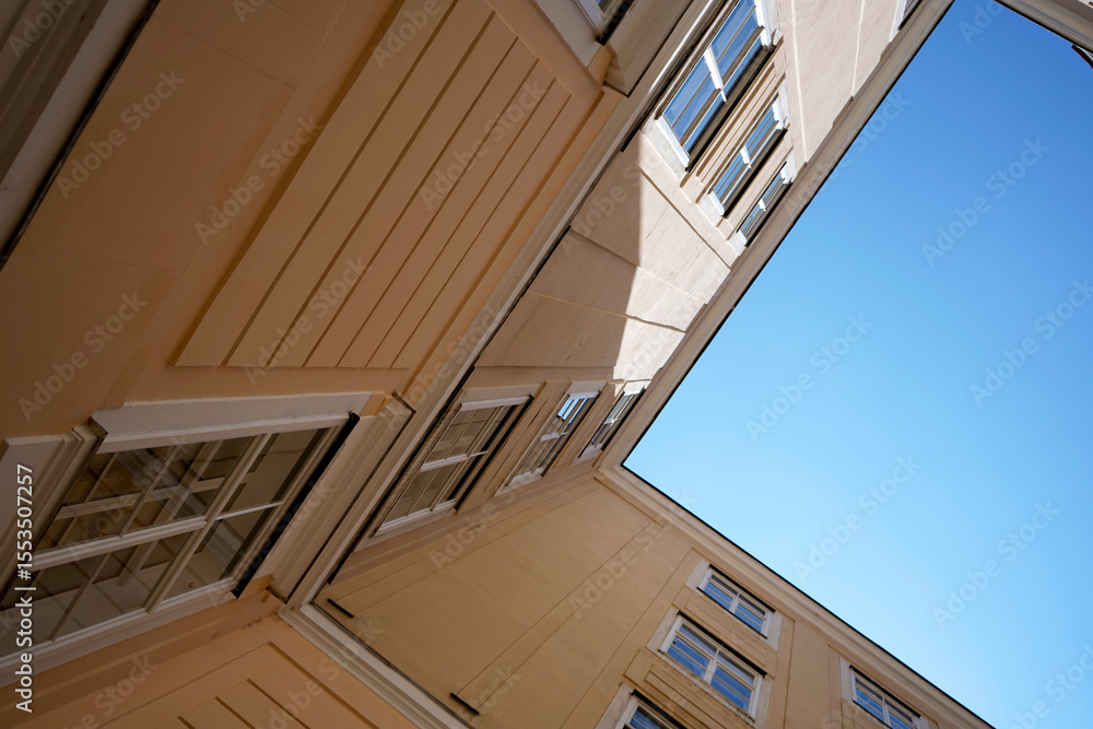 Obraz premium Old yellow building. Clear blue sky. Windows detail. Urban architecture. 
