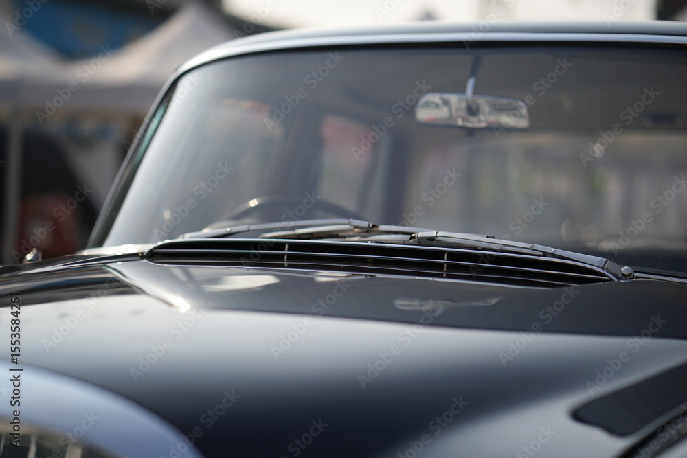 Obraz premium The windshield and chrome wipers of a classic car showcase the timeless allure of vintage automotive design, with their glossy finish and detailed craftsmanship sparking nostalgia for a past era.
