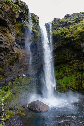 Majestic Kvernufoss waterfall cascading through lush green cliffs in Iceland