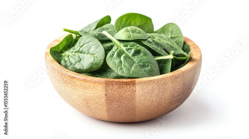 Baby spinach leaves in wooden bowl isolated on white background