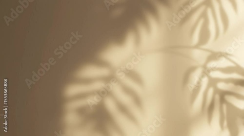 Soft shadows of tropical leaves dapple a beige wall in warm, golden hour light. A serene, minimalist background for summer, wellness, and tranquil home decor concepts.

