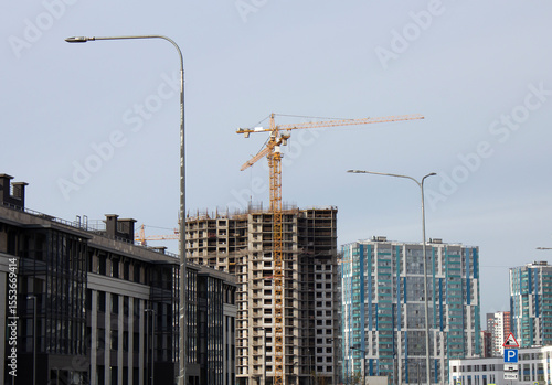 Construction of multi-storey buildings against the blue sky