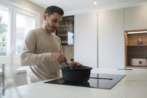 Man cooking lunch in modern kitchen at home
