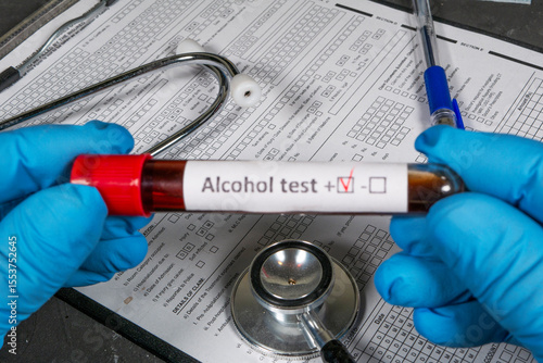Doctor holding positive alcohol test tube near medical documents and stethoscope
