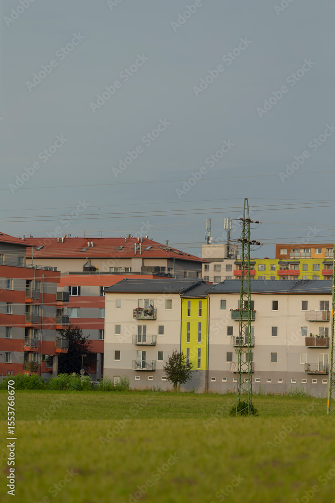 Obraz premium A slightly blurry photograph captures a cityscape, prominently featuring a yellow building in the foreground, adding color and life to the scene