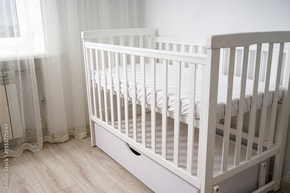 Modern white baby crib in minimalist nursery. Modern white baby crib in minimalist nursery.