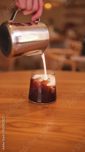 Pouring milk foam into coffee